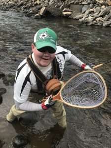 When good fishing is bad, an excited man holding a fly fishing net with a stick in it